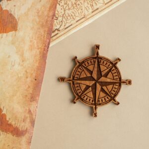 Wooden compass rose and vintage map on beige background, perfect for travel themes.
