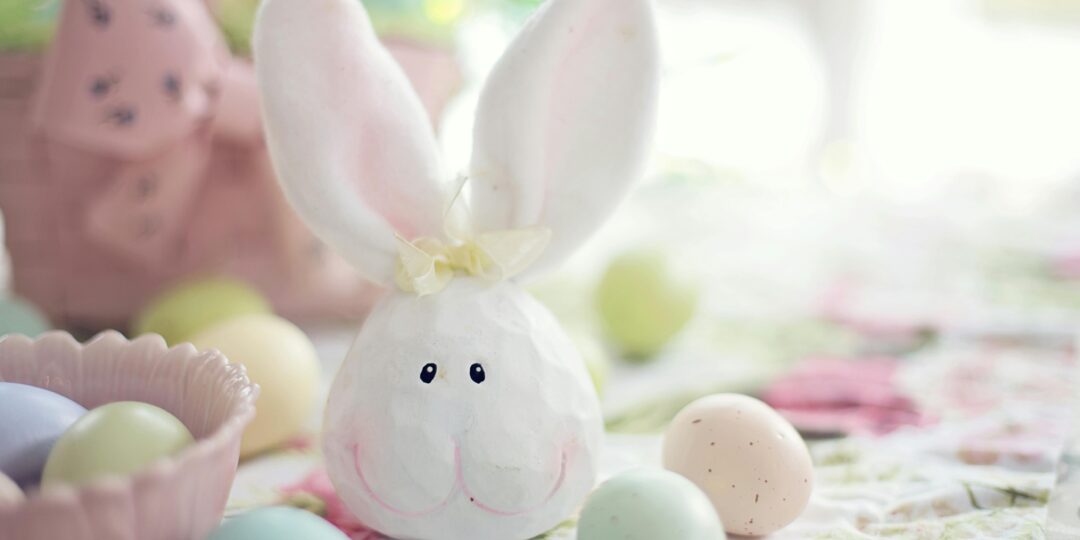 Charming Easter setup featuring a bunny decoration and pastel eggs on a floral tablecloth.