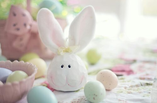 Charming Easter setup featuring a bunny decoration and pastel eggs on a floral tablecloth.