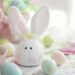 Charming Easter setup featuring a bunny decoration and pastel eggs on a floral tablecloth.