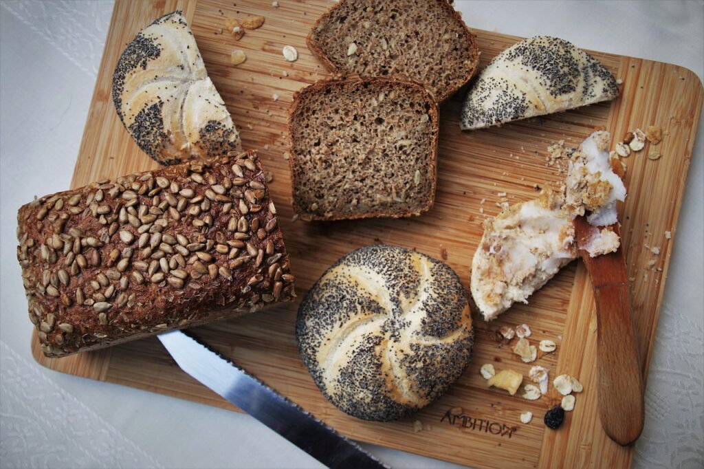 bakery, bread, knife, cutting, loaf, crispy, baked, cereals, calories, in haste, a sandwich, preparation, flour, roll, seeds, breakfast, carbohydrates, eat, fresh, poppy seeds, tasty, home lard, gourmet