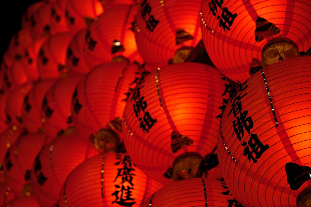 Close-up shot of glowing red Chinese lanterns with calligraphy, symbolizing celebration and tradition.
