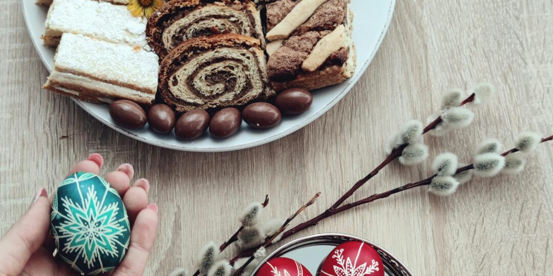 A high-angle shot of Easter pastries and beautifully decorated eggs on a wooden table, perfect for holiday inspirations.