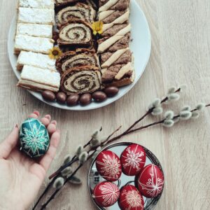 A high-angle shot of Easter pastries and beautifully decorated eggs on a wooden table, perfect for holiday inspirations.