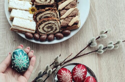 A high-angle shot of Easter pastries and beautifully decorated eggs on a wooden table, perfect for holiday inspirations.