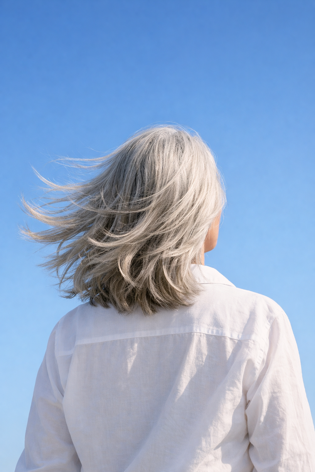 žena 50 plus se stříbrnými vlasy ve větru symbol přirozené krásy a přijetí věku