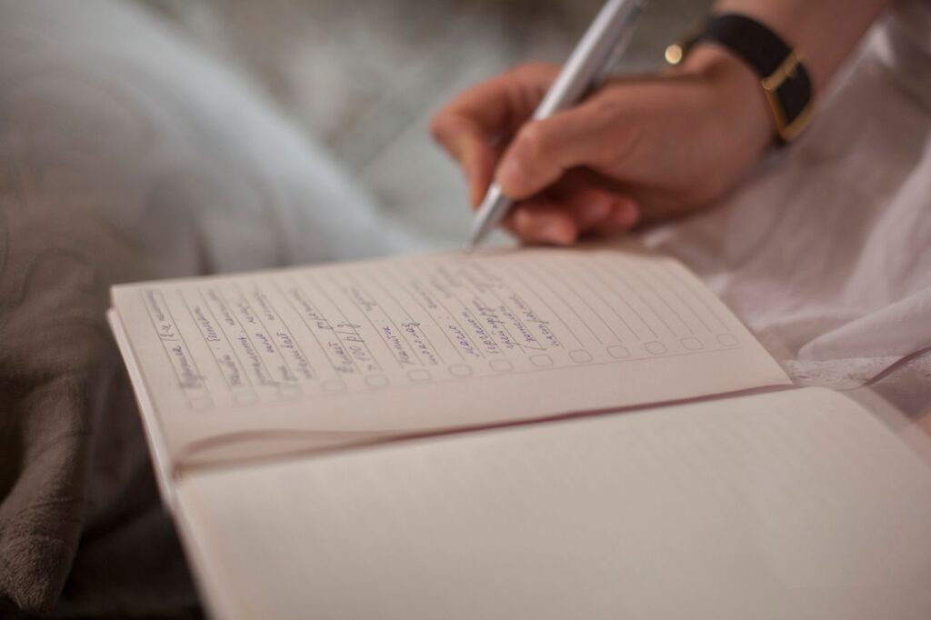 práce, psaní, rozhodování, úpravy, A close-up image of a person's hand writing in a notebook, emphasizing focus and creativity.
